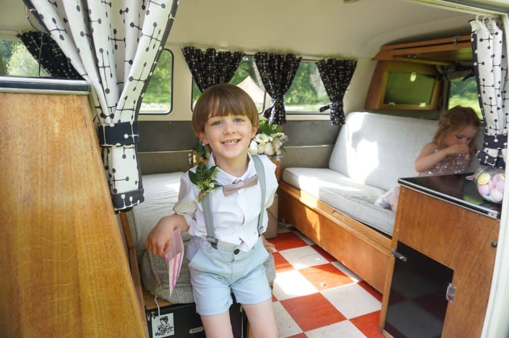 interior of vw camper van with bridesmaid and pageboy. Pictured at The Dreys wedding venue.