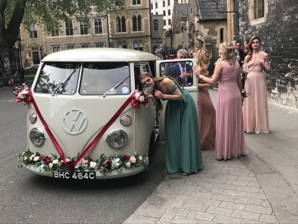 bridesmaids next to wedding car at Westminster Abbey