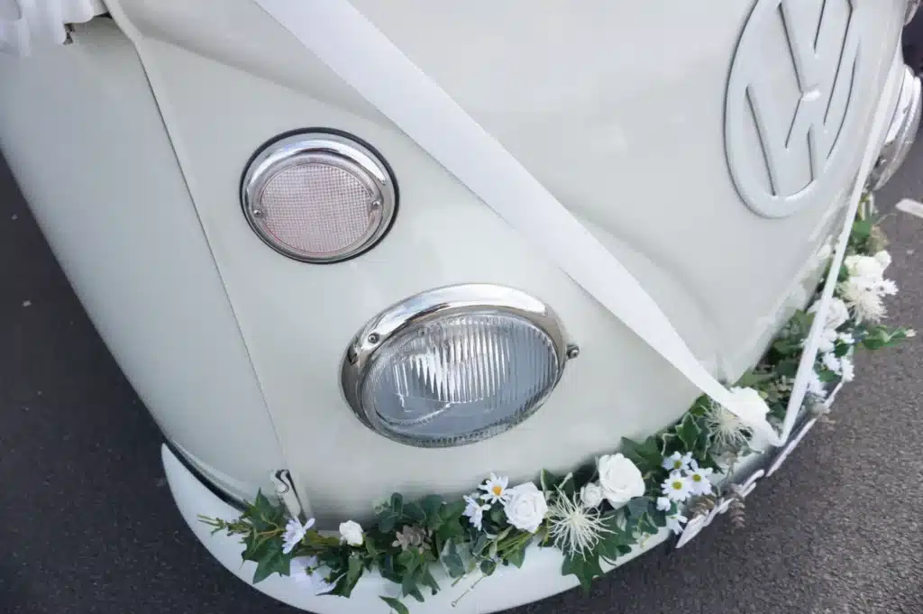 close up of flower garland on the bumper of a wedding car