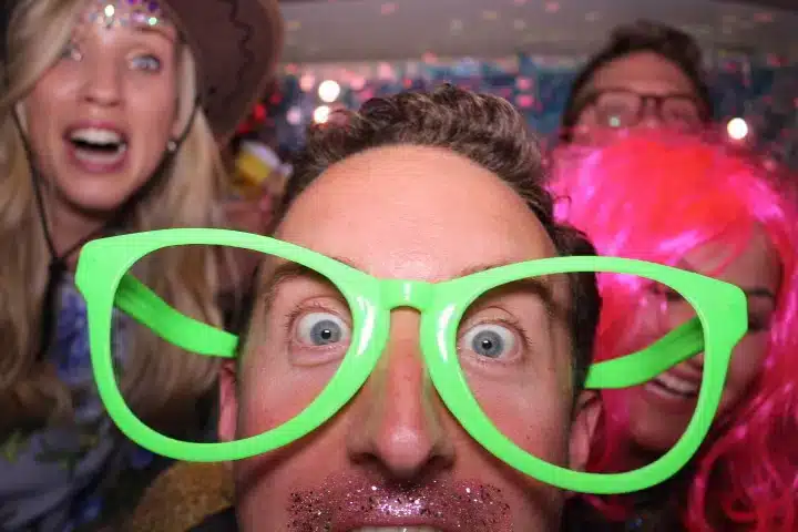 Wedding guests posing with props inside the campervan photo booth